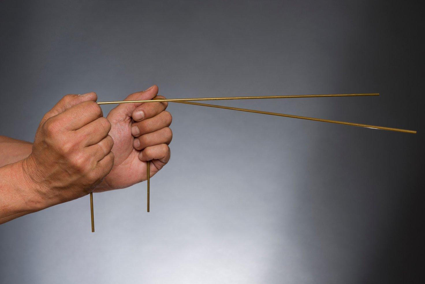 Man holding dowsing rods with both hands